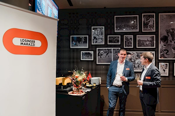 Zwei Gäste im Gespräch während des Business-Events im Wankdorfstadion Bern, fotografiert vom Eventfotografen.