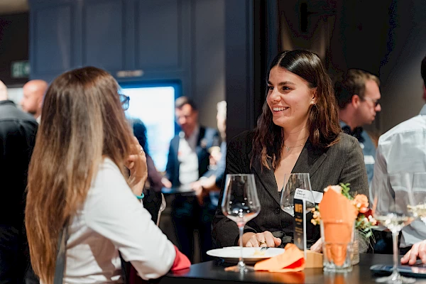 Zwei Teilnehmerinnen im Gespräch beim Apéro des Business-Events in Bern, festgehalten vom Eventfotografen.