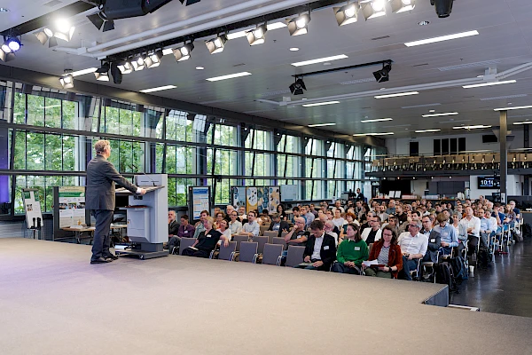 Eventfotograf Bern für Firmenveranstaltungen – Dynamische Fotografie einer Keynote vor großem Publikum in der Eventfabrik Bern. Professionelle, unauffällige Eventfotografie für Business-Events, die Stimmung und Professionalität einfängt.